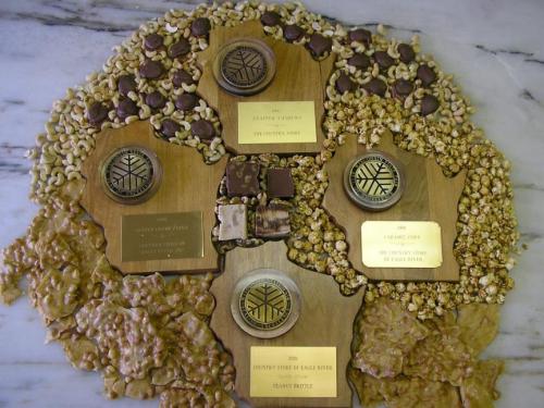 A decorative display of awards and plaques surrounded by popcorn, nuts, and chocolate, arranged in a circular pattern.