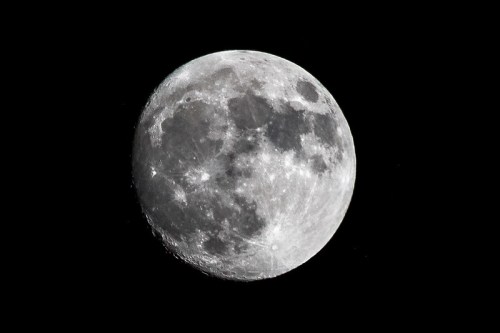 A close-up view of the moon, showcasing its craters and surface details against a black sky.