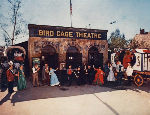 A colorful scene outside the Bird Cage Theatre, featuring performers in period costumes and a vintage wagon.