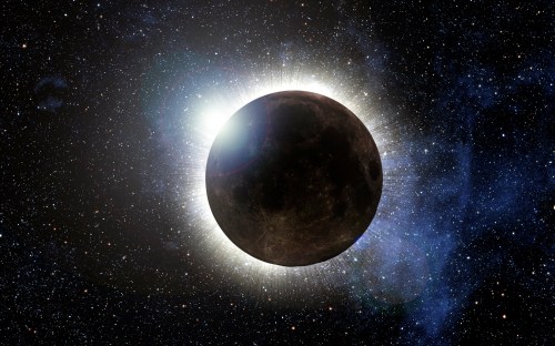 A dark moon partially obscured by a bright halo of light against a starry space background.