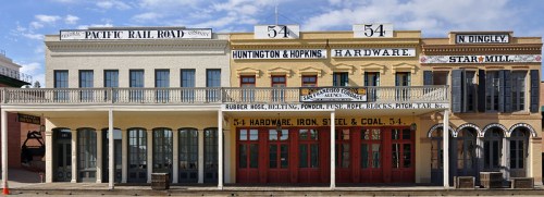 Historic storefronts featuring signage for hardware and coal, with a classic Western architectural style.