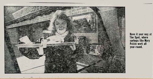A woman holds a tray of food outside a carhop, promoting The Spot restaurant where carhops work year-round.