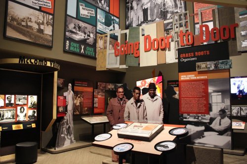 Exhibit titled "Going Door to Door" featuring historical photos and information about grassroots organizing and activism.