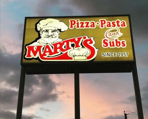 Sign for Marty's featuring pizza, pasta, and subs, with a chef graphic and "Since 1957" text.