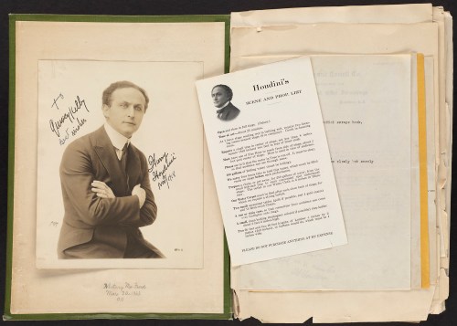 A signed portrait of Harry Houdini with a letter and documents in the background, showcasing his legacy.
