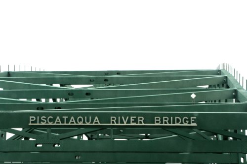 Green steel structure of the Piscataqua River Bridge against a white sky.