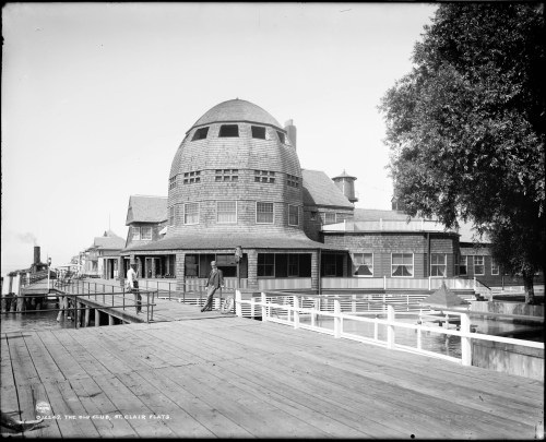 Historic building with a distinctive dome, situated on a pier, surrounded by trees and water. Black and white photo.