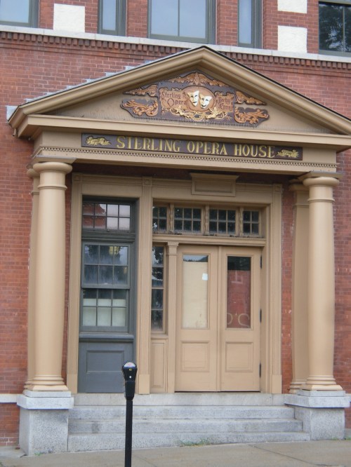 Entrance of the Sterling Opera House, featuring ornate columns and a decorative sign above the doors.