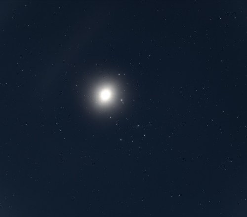 Bright celestial body surrounded by a field of stars against a dark night sky.