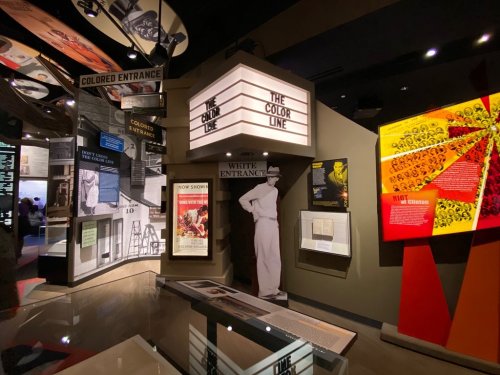 Exhibit showcasing the history of segregation, featuring signs for "Colored Entrance" and "White Entrance."