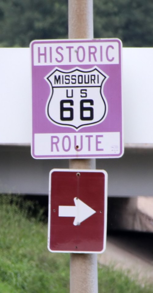 Sign for Historic Route 66 in Missouri, featuring a purple background and an arrow pointing right.