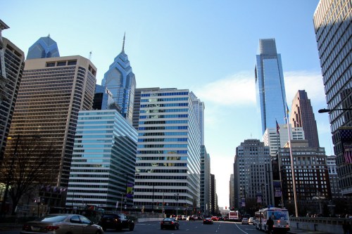 A cityscape of Philadelphia featuring tall skyscrapers and a clear blue sky.