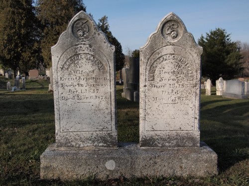 Two weathered gravestones in a cemetery, one on the left for Even G. and the other for William McChristensen.