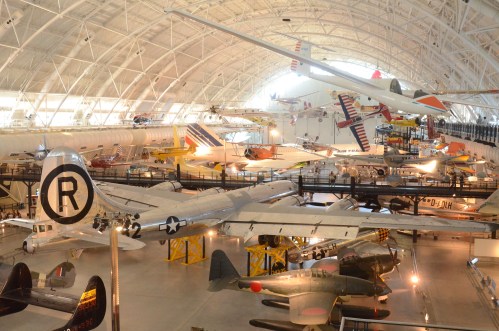 A wide view of an aviation museum showcasing various historic aircraft in a spacious, well-lit hangar.