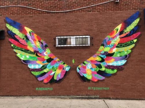 Colorful mural of vibrant wings painted on a brick wall, symbolizing unity and hope. #ARtWIVEPVD #ITSTogether