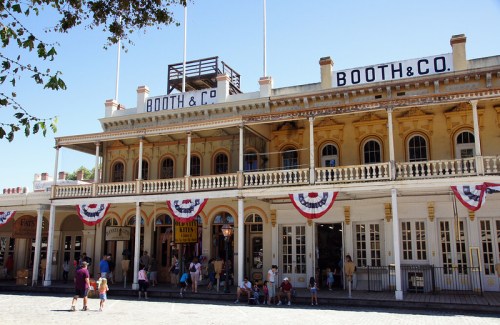 Historic building with "BOOTH & CO" signage, featuring decorative bunting and people gathered outside.