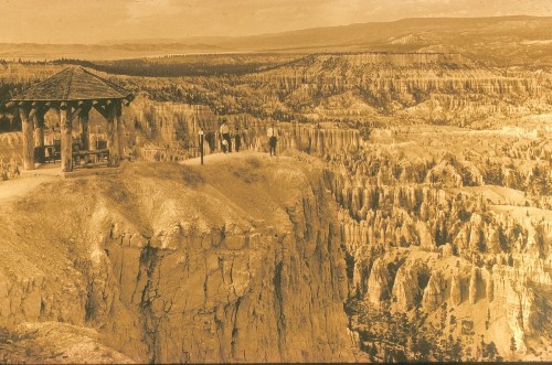 A vintage photo of a gazebo overlooking a canyon with visitors admiring the scenic landscape.