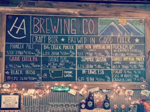 Chalkboard menu displaying various craft beers with names, styles, and alcohol percentages at LA Brewing Co.
