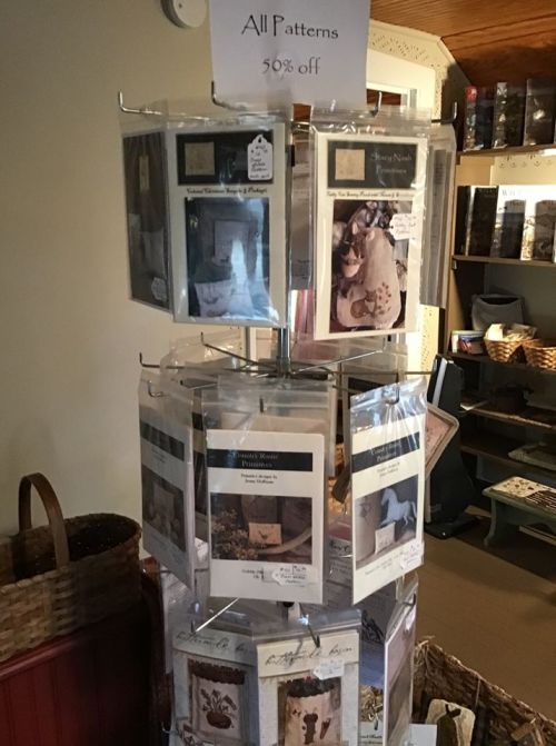 Display rack featuring various craft patterns, with a sign indicating all patterns are 50% off.