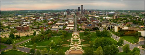Aerial view of a city skyline with green parks and buildings, showcasing urban development and greenery.