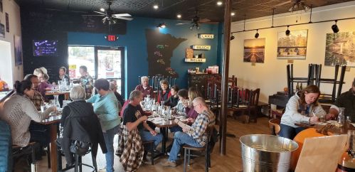 A cozy café scene with patrons enjoying food and drinks at tables, surrounded by a warm, inviting atmosphere.