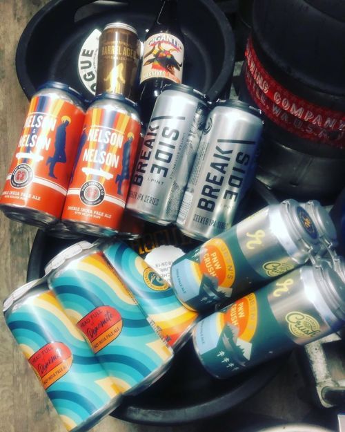 A collection of various beer cans and bottles arranged in a circular display, showcasing colorful labels and designs.