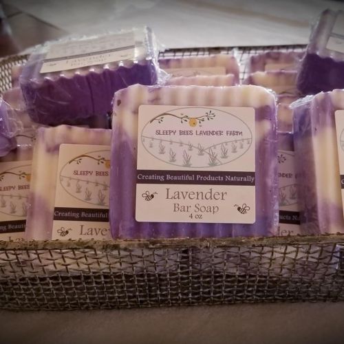 A basket filled with lavender bar soaps, each labeled with "Sleepy Bees Lavender Farm."