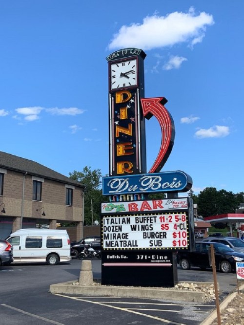 Sign for Du Bois Diner featuring a clock, menu items, and prices for buffet, wings, burgers, and subs.