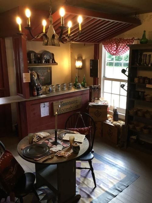 A cozy room with a table set for a meal, vintage decor, and a window letting in natural light.