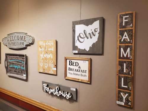 A collection of decorative wall signs featuring phrases like "Welcome to the Farm," "Ohio," and "Family."