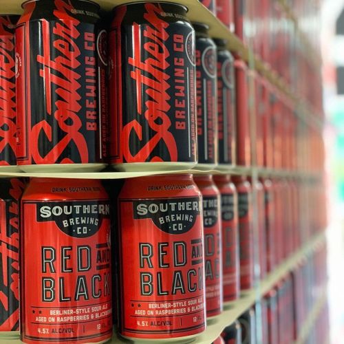 A close-up of stacked Southern Brewing Co. cans, featuring "Red and Black" Berliner-style sour ale labels.
