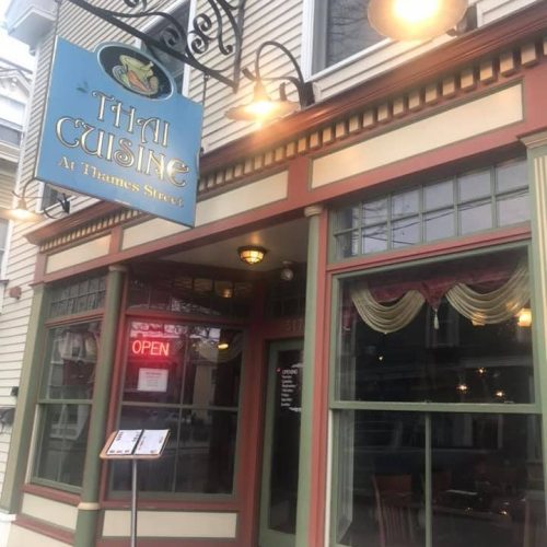 Exterior of a Thai restaurant with a colorful sign, "Thai Cuisine at Thames Street," and an "Open" sign in the window.