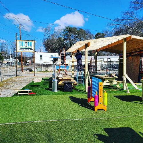 A construction site with a wooden structure, playground equipment, and a blue sky in the background.
