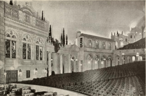 Interior view of a grand theater with ornate architecture and rows of empty seats.