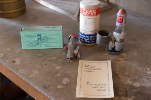 A collection of vintage scientific instruments, including a hydrometer, a measuring device, and a box of accessories.