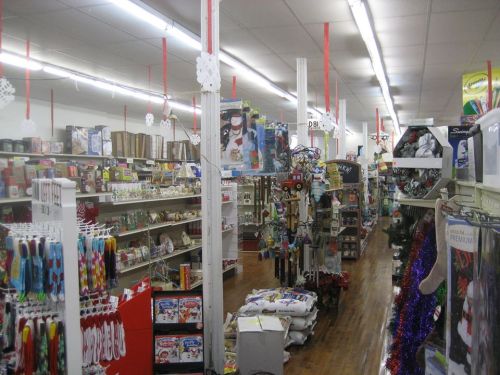 A brightly lit store aisle filled with holiday decorations, gifts, and seasonal items on shelves.
