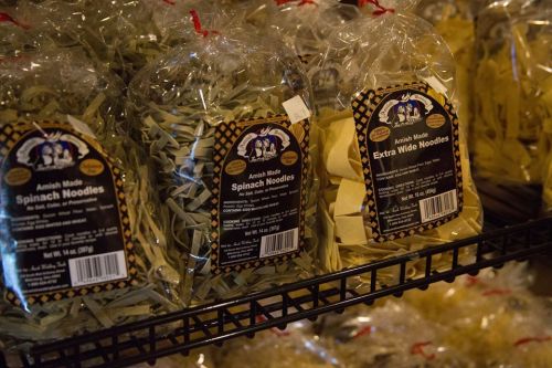 Packages of spinach and extra wide noodles on a store shelf, labeled "Amish Made."
