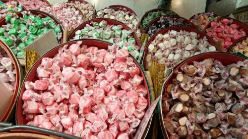 Colorful assorted candies in various shades, neatly arranged in round containers.