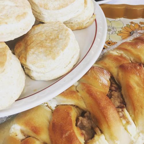 A plate of golden biscuits and a braided pastry filled with meat, arranged on a decorative tray.