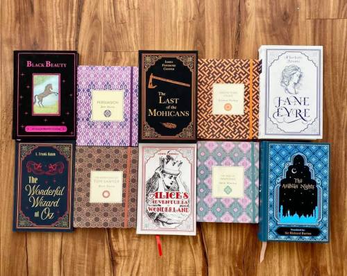 A collection of classic books displayed on a wooden surface, featuring colorful covers and titles like "Jane Eyre" and "Alice's Adventures in Wonderland."