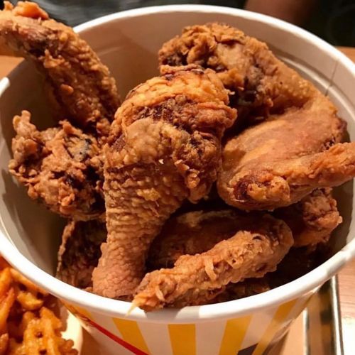 A bucket filled with crispy, golden-brown fried chicken wings.