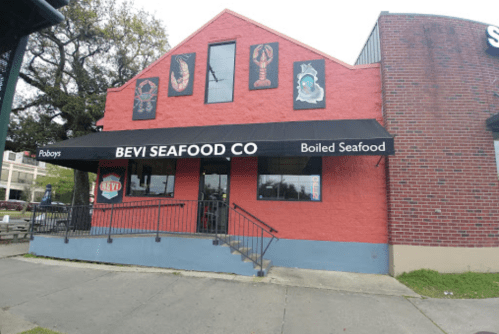 Exterior of Bevi Seafood Co., a red building with seafood-themed decorations and a black awning.