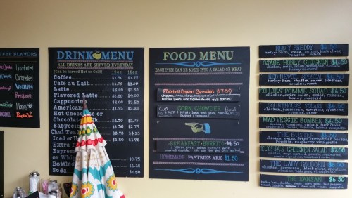A café menu featuring drinks and food options, including specials and prices, displayed on chalkboards.