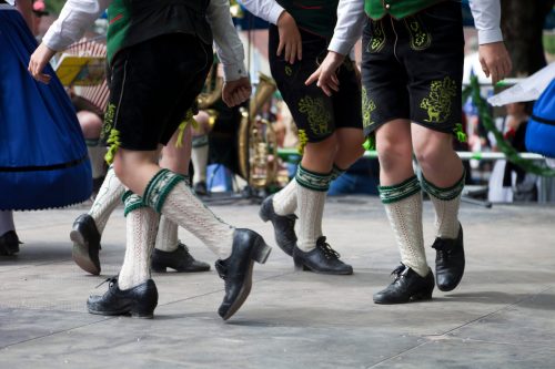 Dancers in traditional attire perform on stage, showcasing intricate footwork and cultural celebration.