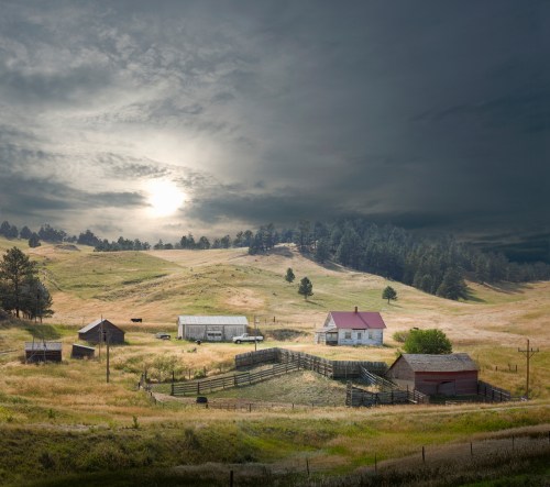 A serene rural landscape featuring a farmhouse, barns, and a fenced area under a dramatic sky with soft sunlight.