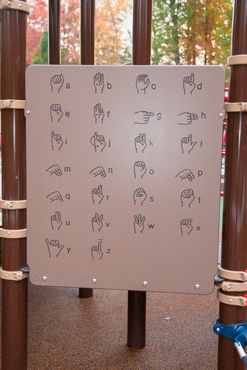 A playground sign displaying the American Sign Language alphabet in hand shapes from A to Z.