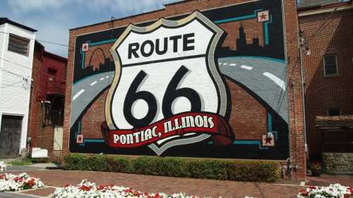 Mural of Route 66 in Pontiac, Illinois, featuring a colorful highway sign on a brick wall.