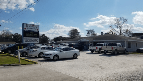 A seafood restaurant with a parking lot full of cars, under a clear blue sky with a few clouds.