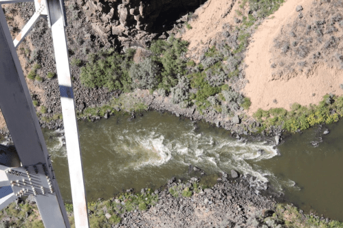 Aerial view of a winding river surrounded by rocky banks and lush greenery.