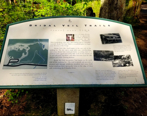Sign for Bridal Veil Trails, detailing the area's history and scenic views along the Columbia River. Surrounded by trees.